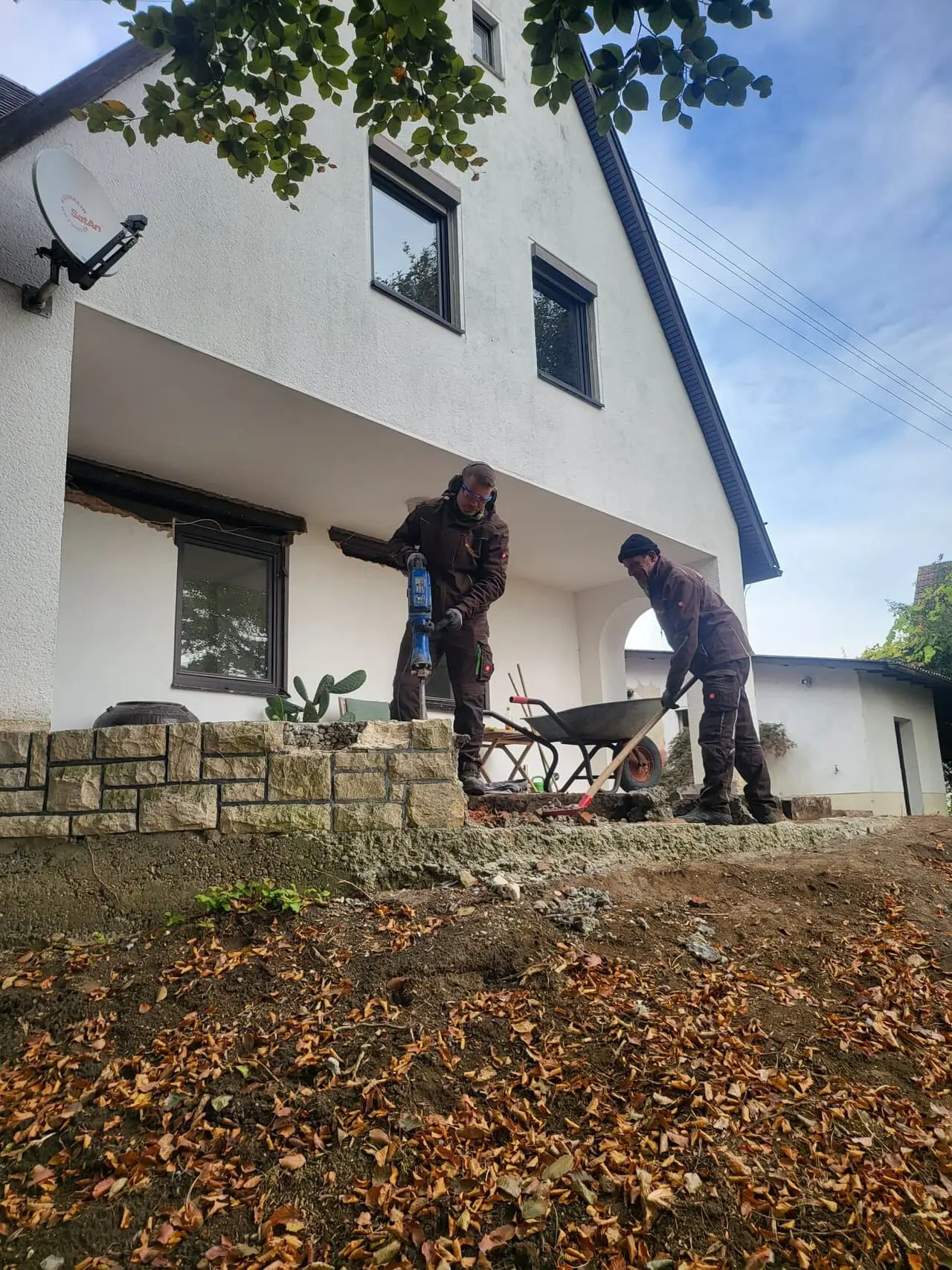 Zwei Mitarbeiter der Neumüller GmbH beim Rückbau einer Terrasse an einem Wohnhaus