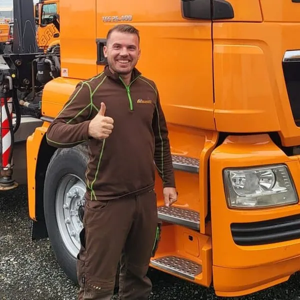 Mitarbeiter der Neumüller GmbH vor einem Abrollkipper des Betriebs